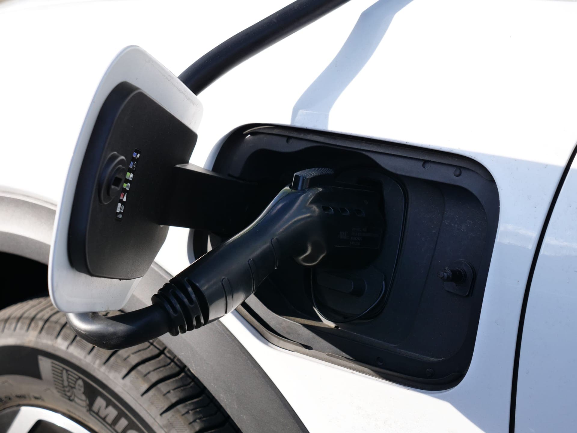 A coiled EV charging cable and connector on a clean surface
